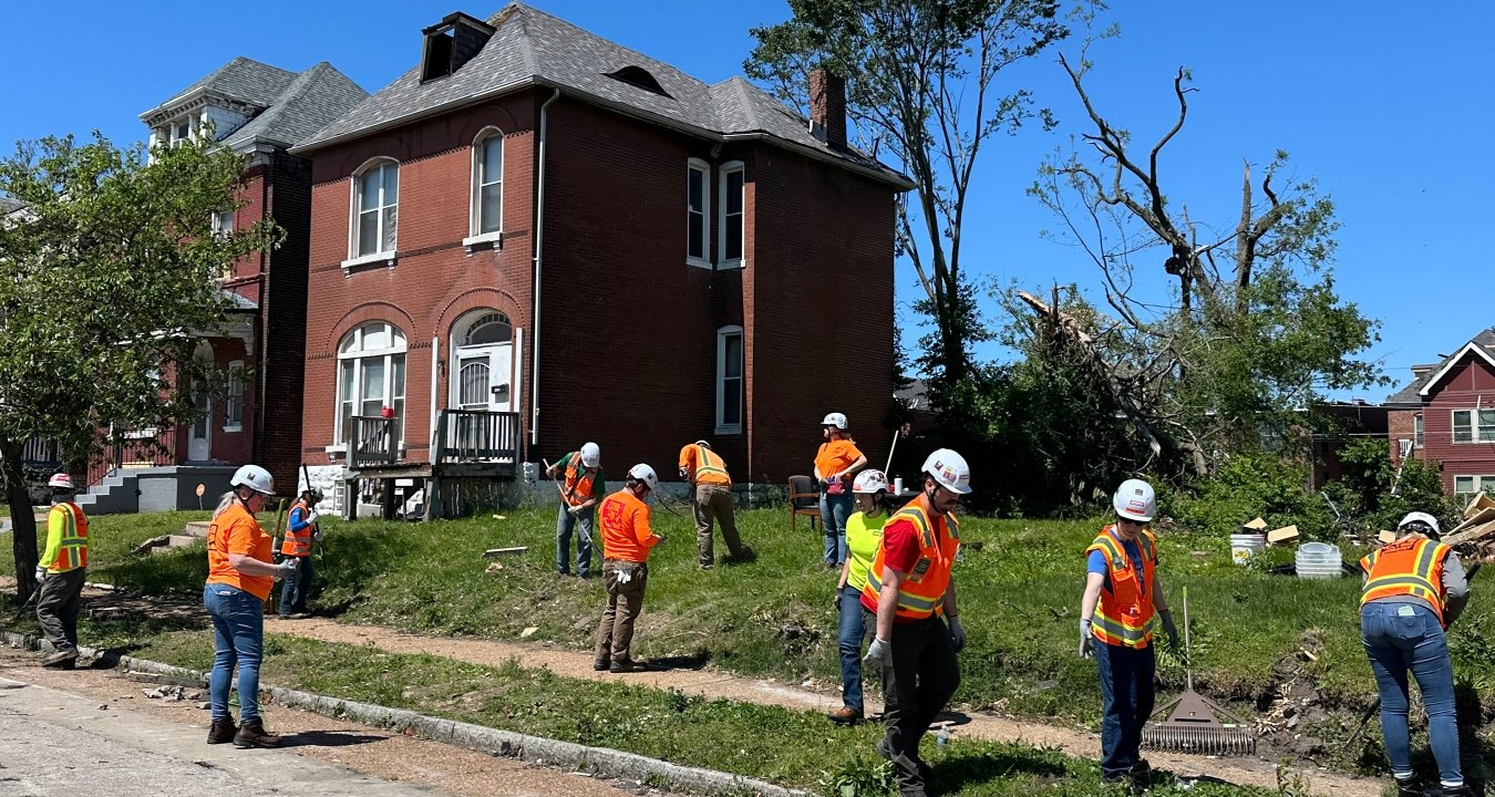 Group of people cleaning up an area in St. Louis following a tornado.