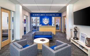 A sitting area with couches and a small table. SLU logo is on the wall in the background.