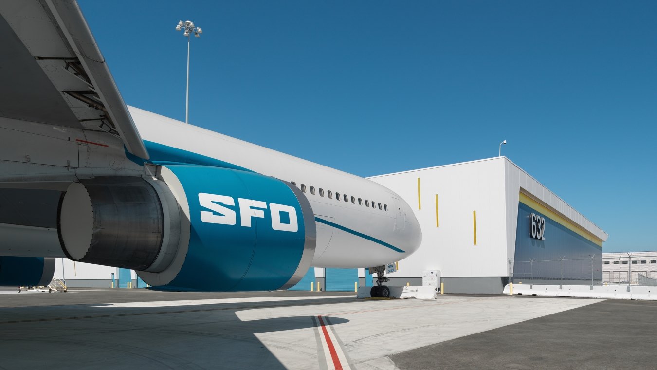 A parked airplane with letters SFO on the engine.