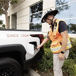 A person plugging a charger into an electric vehicle