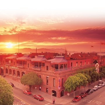 Aerial exterior view of The Cannery with a sunset in the background.
