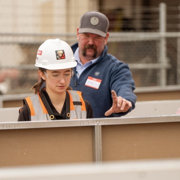 Two people learning from someone else during a Construction 101 event. 