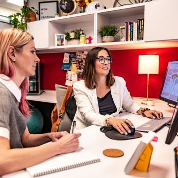 Two people sitting at a desk.