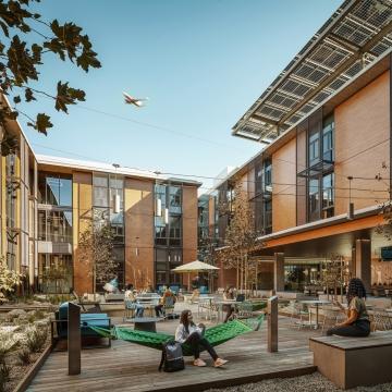 People enjoying a courtyard area at a student housing facility