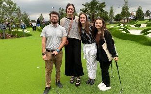 Four interns at the kickoff event playing mini golf