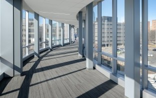 A long hallway with windows on both sides and light beaming in.