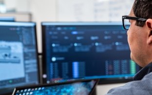 man sitting at his desk looking at a computer